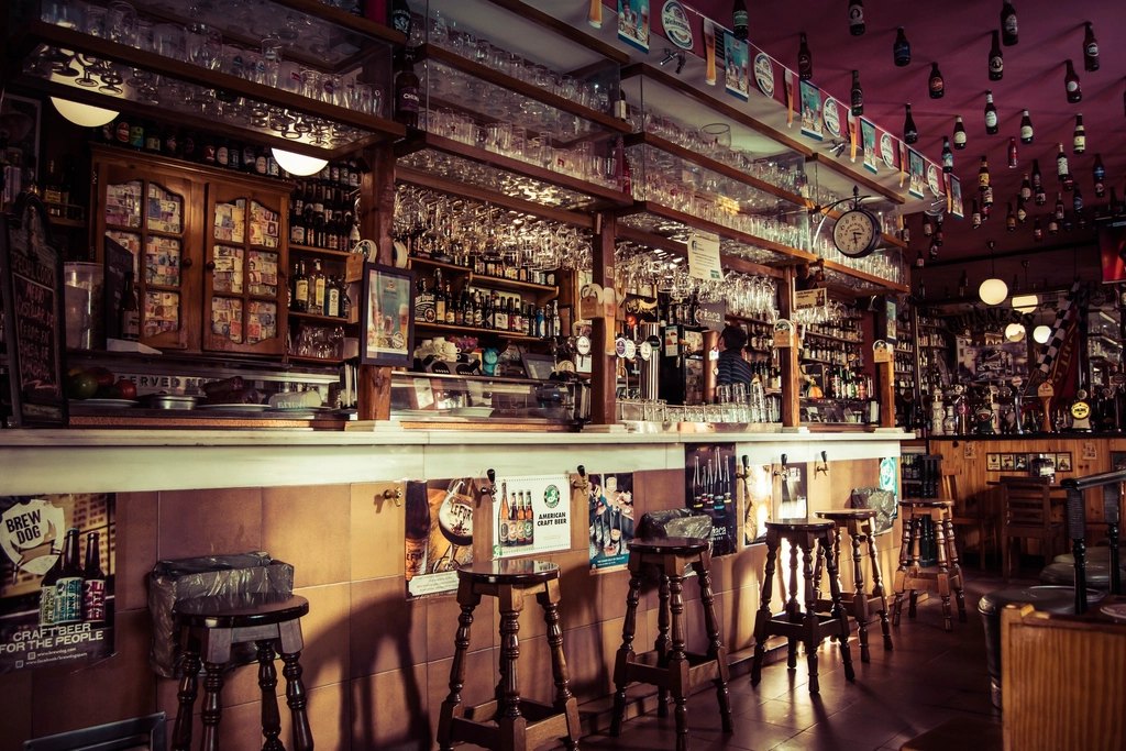 Salón de bar con banquetas, penumbra